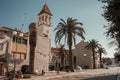 Narrow old streets and courtyards in Croatia, a medieval area with huge palm trees and a building with a tower Royalty Free Stock Photo