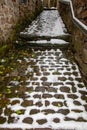 Narrow passage between ancient stone walls in winter Royalty Free Stock Photo