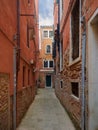 Narrow passage between colorful houses, Venice