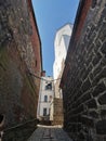 A narrow passage with a lantern suspended on chains, between the stone walls of the Vyborg Castle to the courtyard to the Tower of Royalty Free Stock Photo