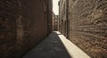 Narrow passageway between two tall brick buildings, creating a deep perspective. The Royalty Free Stock Photo