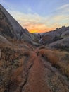 A narrow path among the bright red and rose limestone hills in Cappadocia, Turkey