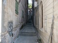 Narrow path in old house walls with stone stairs, windows and iron lamp Royalty Free Stock Photo