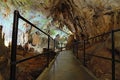 Narrow pathway between stalactites and stalagmites. Mystical view of Postojna Cave. Famous touristic place and romantic travel Royalty Free Stock Photo