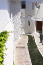 Narrow paved street with a depression for a mountain stream, white houses decorated with lanterns, Capileira, Andalusia, Spain