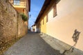 Narrow paved street among houses in Saluzzo.