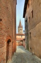 Narrow paved street among houses in Saluzzo.