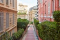 Narrow pedestrian alley in Monte Carlo with luxury buildings, summer day in Monaco