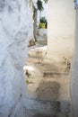 Narrow pedestrian street with stairs and white clay walls in Plaka, Athens