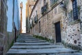 Narrow picturesque alley with stairs and stone houses in the town of Caceres.