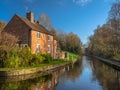 Narrow river surrounded by trees and houses under the sunlight in Ironbridge, England Royalty Free Stock Photo