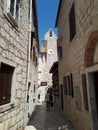 Narrow romantic street with stone buildings with church view decorated for festival in old town of Rab Croatia