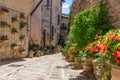 The narrow romantic street of the town of Spello is decorated wi