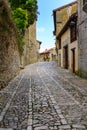 Narrow steep street with old houses and old stone pavement. Santillana del Mar