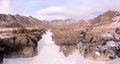 A narrow stone canyon and a river frozen in it in a beautiful mountain valley on a sunny winter day Royalty Free Stock Photo