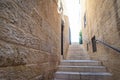Narrow stone steps in an alley in the Jewish Quarter, with a handle for accessibility for the disabled,