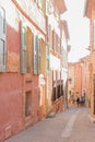 A narrow street in the beautiful French village of Roussillon, where the buildings are made with colorful. Luberon, France