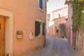 A narrow street in the beautiful French village of Roussillon, where the buildings are made with colorful Royalty Free Stock Photo