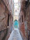 Narrow street and blue door in the city of Venice, Italy Royalty Free Stock Photo