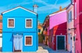 Narrow street with blue, red, green and purple house facade in the island of Burano, Venice Royalty Free Stock Photo