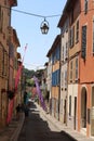 narrow street in a French little town with colorful facades, shutters and flags