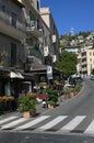 Narrow street with densely parked cars. Typical Sicilian street with old residential houses, open-air cafes and small shops Royalty Free Stock Photo