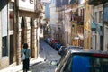A narrow street in Europe, a lot of parked cars, mountain Porto, high rises and low descents