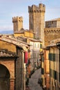 Narrow street in historic center of Montalcino town with fortre