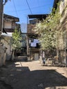 Narrow street, lane, tunnel with old houses, buildings on the sides in a poor area of the city, slums. Vertical photo