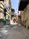 Narrow street, lane, tunnel with old houses, buildings on the sides in a poor area of the city, slums. Vertical photo Royalty Free Stock Photo