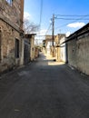 Narrow street, lane, tunnel with old houses, buildings on the sides in a poor area of the city, slums. Vertical photo Royalty Free Stock Photo