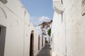 Narrow street in Lindos town on Rhodes island, Dodecanese, Greece. Beautiful scenic old ancient white houses Royalty Free Stock Photo