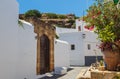 Narrow street in Lindos town on Rhodes island, Dodecanese, Greece. Beautiful scenic old ancient white houses with flowers. Famous Royalty Free Stock Photo