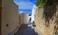 Narrow street in Lindos town on Rhodes island, Dodecanese, Greece. Beautiful scenic old ancient white houses with flowers. Famous Royalty Free Stock Photo