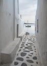 A narrow street in Little Venice overlooking the sea and a yacht on island of Mykonos in Greece Royalty Free Stock Photo
