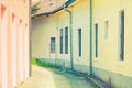 Narrow street between old bright houses with eaves