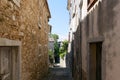 Narrow street between old houses in Motovun on a sunny day