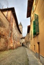 Narrow street among old houses in Saluzzo, Italy.