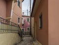 Narrow street and with old red houses with flaking facade, green door and window, vintage look, Corfu Greece Royalty Free Stock Photo