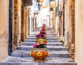 Narrow street in the old town of Cefalu, medieval village on Sicily island, Italy. Flower pots with traditional sicilian Royalty Free Stock Photo