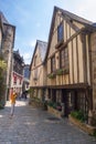 Narrow street with old traditional houses in histoical part of Dinan, Brittany, France Royalty Free Stock Photo