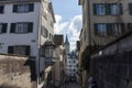 Narrow street in old Zurich. In the distance the clock tower of St. Peter\'s Church Royalty Free Stock Photo