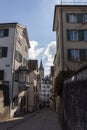 Narrow street in old Zurich. In the distance the clock tower of St. Peter\'s Church Royalty Free Stock Photo