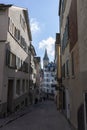 Narrow street in old Zurich. In the distance the clock tower of St. Peter\'s Church Royalty Free Stock Photo