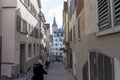 Narrow street in old Zurich. In the distance the clock tower of St. Peter\'s Church Royalty Free Stock Photo