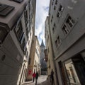 Narrow street in old Zurich. In the distance the clock tower of St. Peter\'s Church Royalty Free Stock Photo