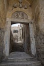 Narrow street in slope, with an arch and stairs, in stone, in Dubrovnik, Croatia