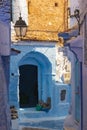 Narrow street with some houses with old doors, all painted blue in the medina of Chefchaouen, Morocco Royalty Free Stock Photo