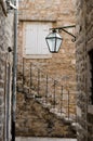 Narrow street, stairs, old town and vintage lantern on the wall. Royalty Free Stock Photo