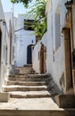 Narrow lane with stairs and white houses in Lindos on Greek island Rhodes